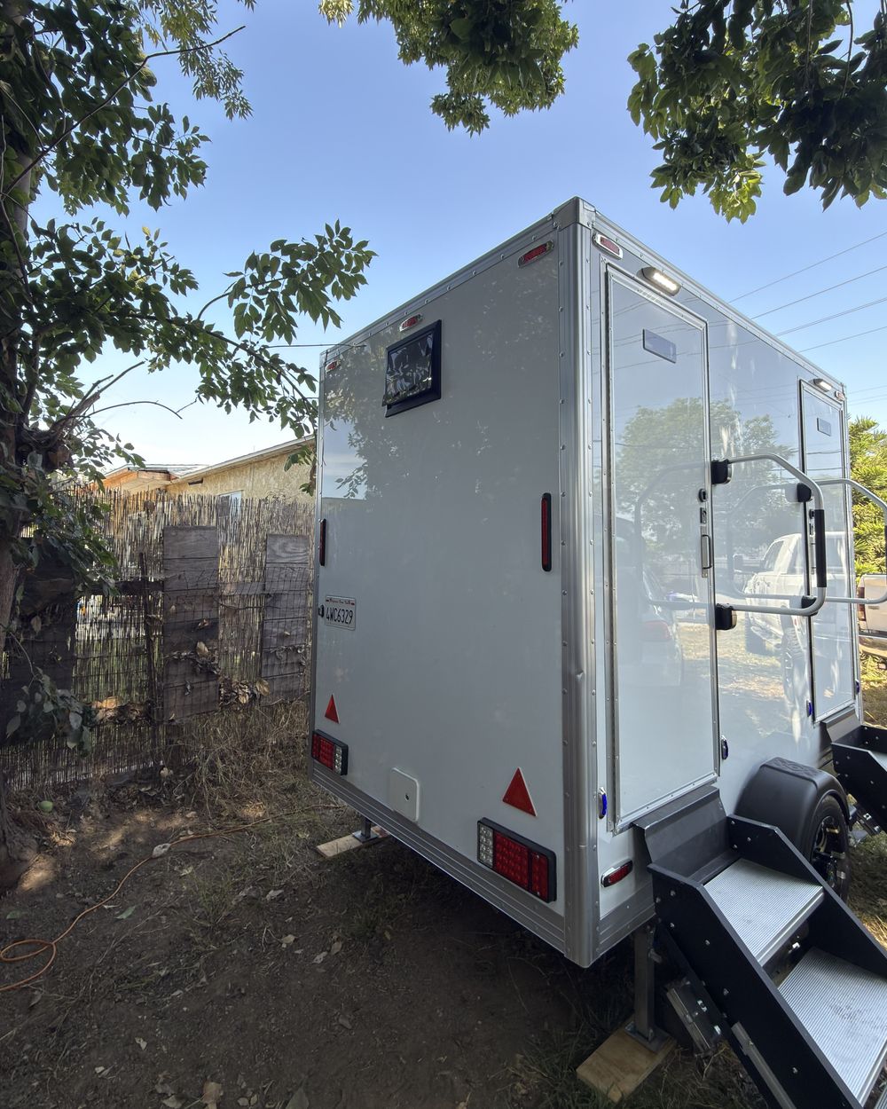 The trailer from the rear, levelled on its stabilisers with the entry steps extended and the door open.